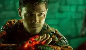 Cole Young (Lewis Tan), a bloodied, sweaty young man wearing glowing woven armor, looks determined in Mortal Kombat 2