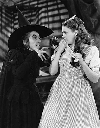 Karakter oyuncusu Margaret Hamilton (solda) gerçek hayatta "tatlı, nazik bir kadındı". Broadway ve Hollywood'da çalışmadan önce anaokulu öğretmenliği bile yaptı ve bu, 1939 filmindeki Oz Büyücüsü  filminde Batının Kötü Cadısı rolünün kişiliğinden oldukça farklıydı.[9]